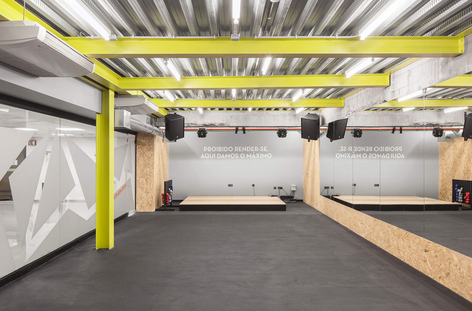 The beam structure that supports the ceiling was painted in yellow in order to give a distinct identity to the fitness studio compared to the other spaces.
